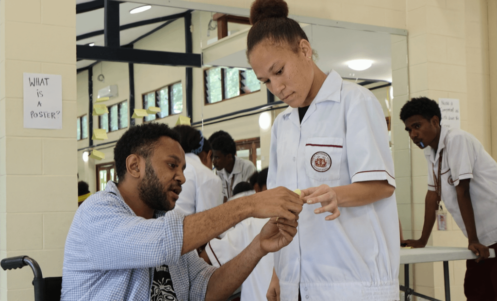 Samuel assisting a student from Gordons Secondary School during a Youth Arts Program activity last month.